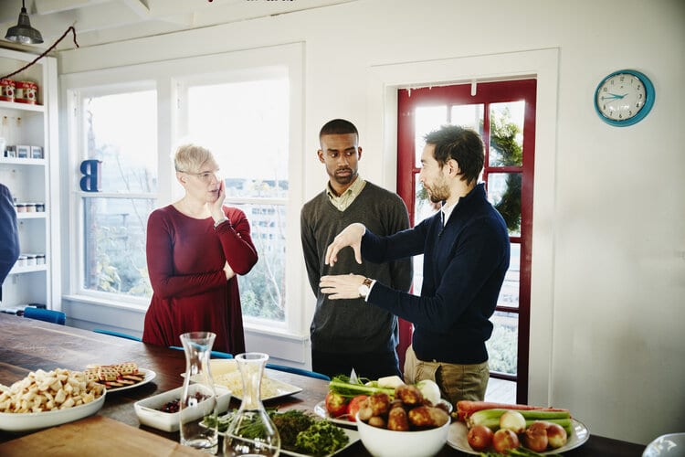 Three Friends In Discussion Before Holiday Dinner Party